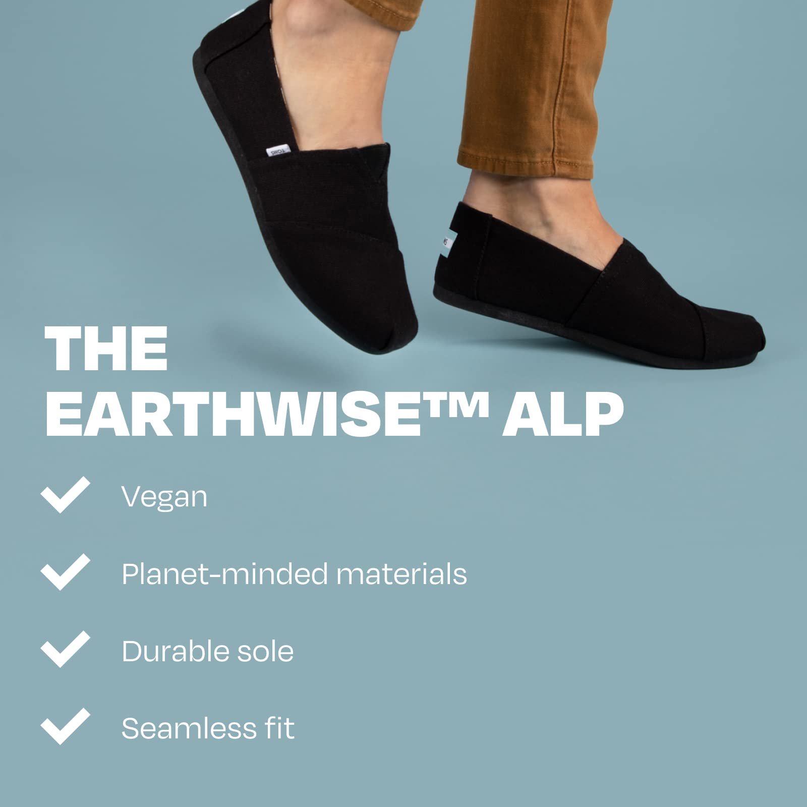 A woman in black TOMS Alpargata slip-ons and brown pants balances on one foot against a blue backdrop. Text highlights the shoes’ vegan, planet-friendly materials, recycled cotton, durable sole, and seamless fit.