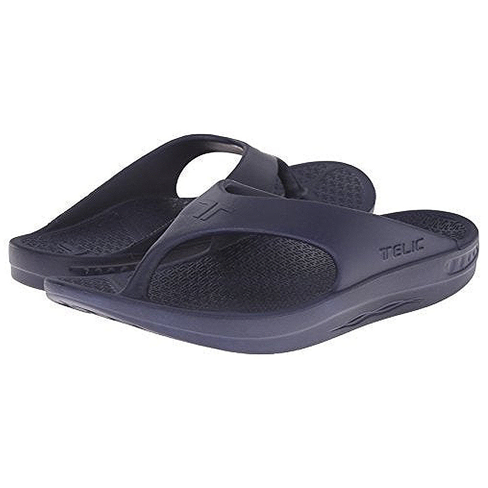 A pair of dark blue Telic Footwear Energy Flip Flop - Unisex sandals with thick, pillow-soft cushioning and textured footbeds, shown slightly overlapping each other.