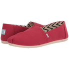 The TOMS Alpargata - Womens are red slip-on canvas shoes with beige soles, a chevron-patterned lining, and small white side and heel tags showing the TOMS name. Made from recycled cotton.