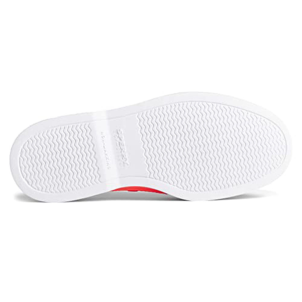 The image shows the bottom view of a Sperry Authentic Original Float Boat - Women sneaker with a white sole, subtle zigzag tread and wave-siping traction, an embossed logo in the center, and a slightly red side.