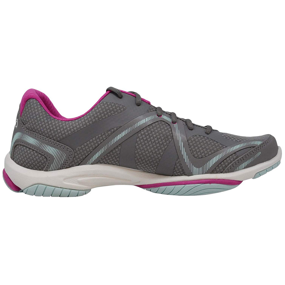The Ryka Influence - Women is a gray workout shoe with light blue and pink accents, featuring mesh texture and supportive overlays. Seen from the side, it’s a lightweight cross-trainer ideal for versatile workouts.