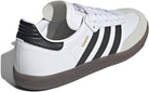 The adidas Samba OG - Men features a white leather upper, black stripes, brown rubber sole, suede toe cap, gold SAMBA lettering on the side, black heel detailing, and a classic lace-up closure for timeless street style.