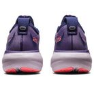 The image shows the back view of ASICS Gel Nimbus 25 - Womens shoes in purple and pink, with “25” on the heel and thick soles featuring pink accents. These ASICS running shoes offer lightweight cushioning and comfort.