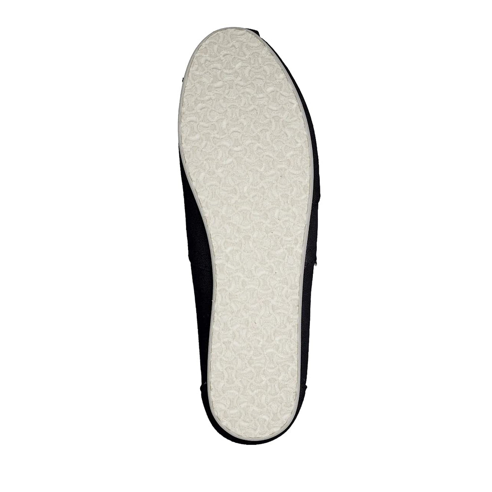 The image shows the sole of a TOMS Classic Canvas - Men alpargata, with a light-colored, textured rubber pattern for grip. The upper edges are black and just visible from this angle.