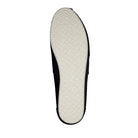 The image shows the sole of a TOMS Classic Canvas - Men alpargata, with a light-colored, textured rubber pattern for grip. The upper edges are black and just visible from this angle.