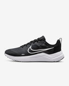 The Nike Downshifter 12 - Women’s running shoe in black features a white swoosh logo and thick white sole, offering lightweight support; shown from the side against a plain white background.