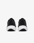 A pair of womens Nike Downshifter 12 running shoes in black with white soles, featuring lightweight support, displayed from the back on a plain white background.