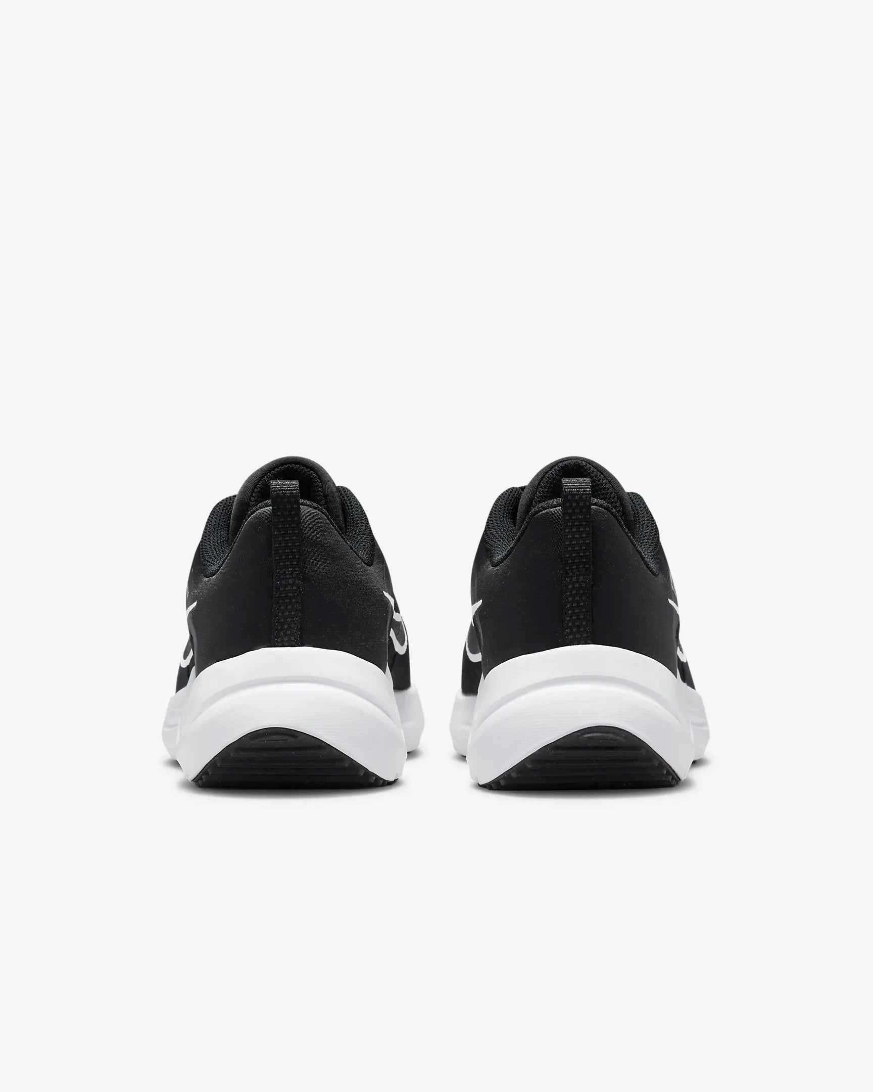 A pair of womens Nike Downshifter 12 running shoes in black with white soles, featuring lightweight support, displayed from the back on a plain white background.