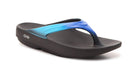 The OOFOS OOlala Sandal - Unisex in Black/Bluejay features a thick wedge sole, blue gradient strap, and OOfoam technology for superior recovery, shown on a white background.